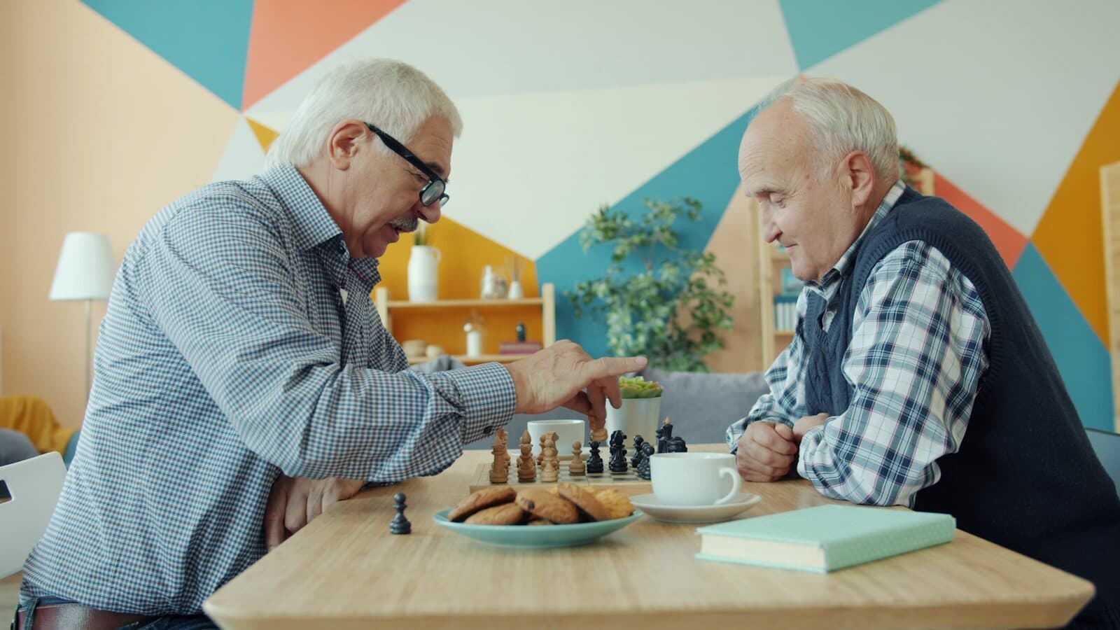 Two elderly men playing chess at a table.